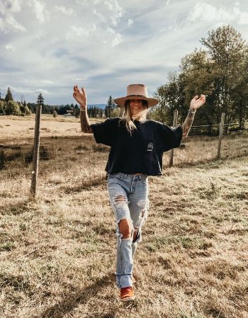 An Oversized Crop T-Shirt Compared With Ripped Jeans And Sneakers With a Wide-Brimmed Hat