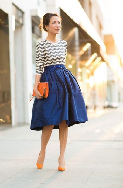A chevron Blouse, An A-Line Midi Skirt, And An Orange Clutch