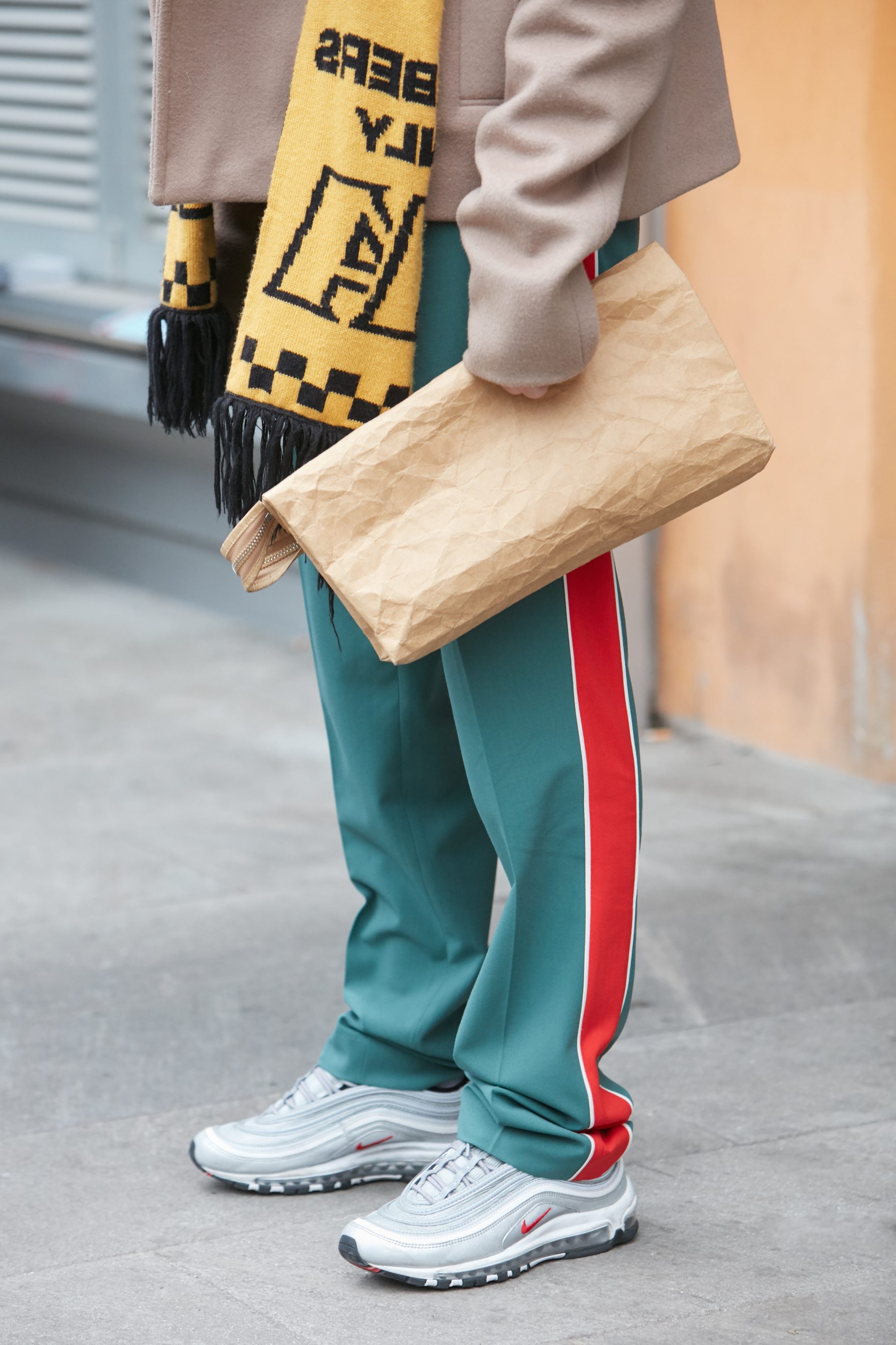 Jacket, Blue Pants With Red Stripes, And Gray Nike Shoes