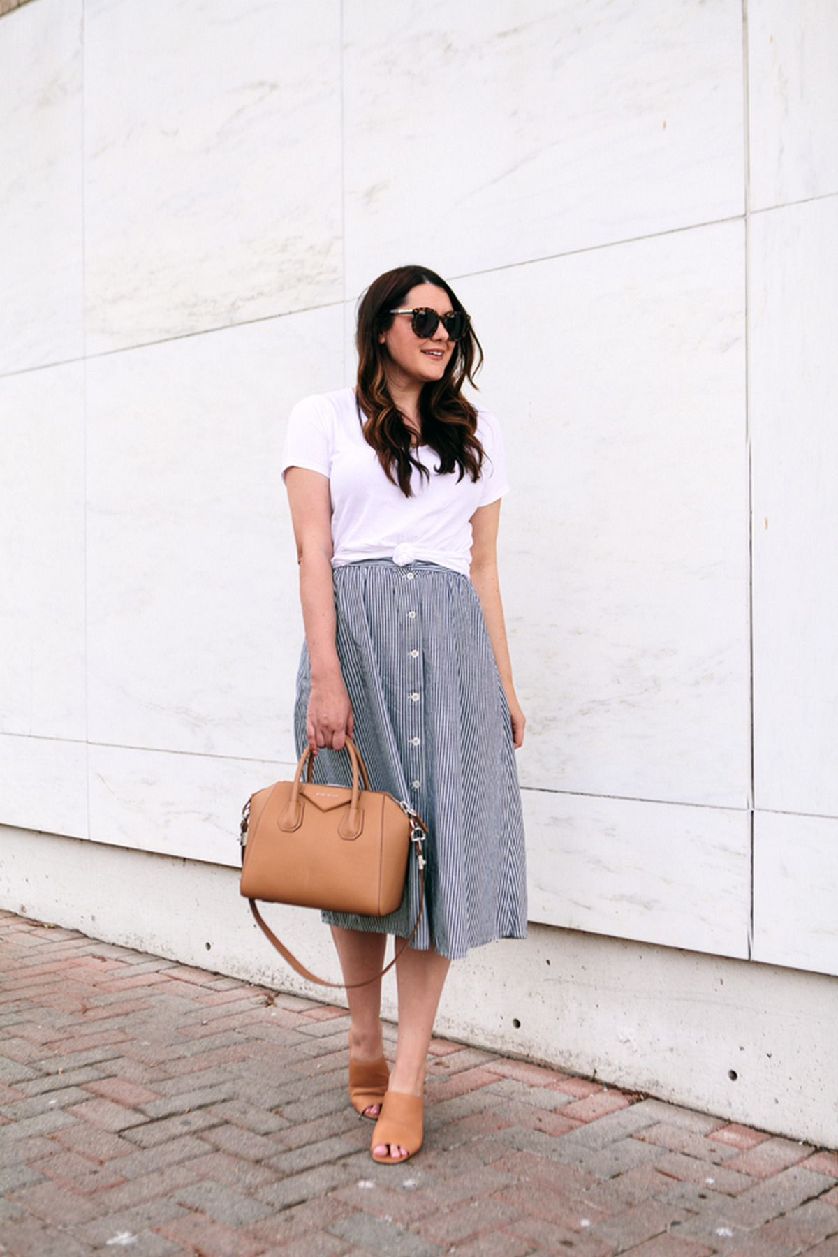 Mules With A Simple Dark T-Shirt Tucked In A Midi Skirt