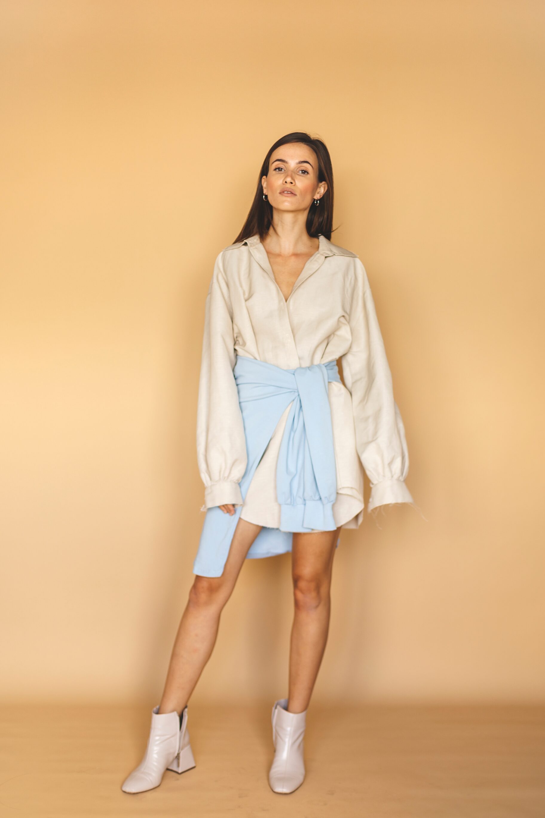 Beige Shirt Dress, Boots, And Blue Hoody Tied At The Waist