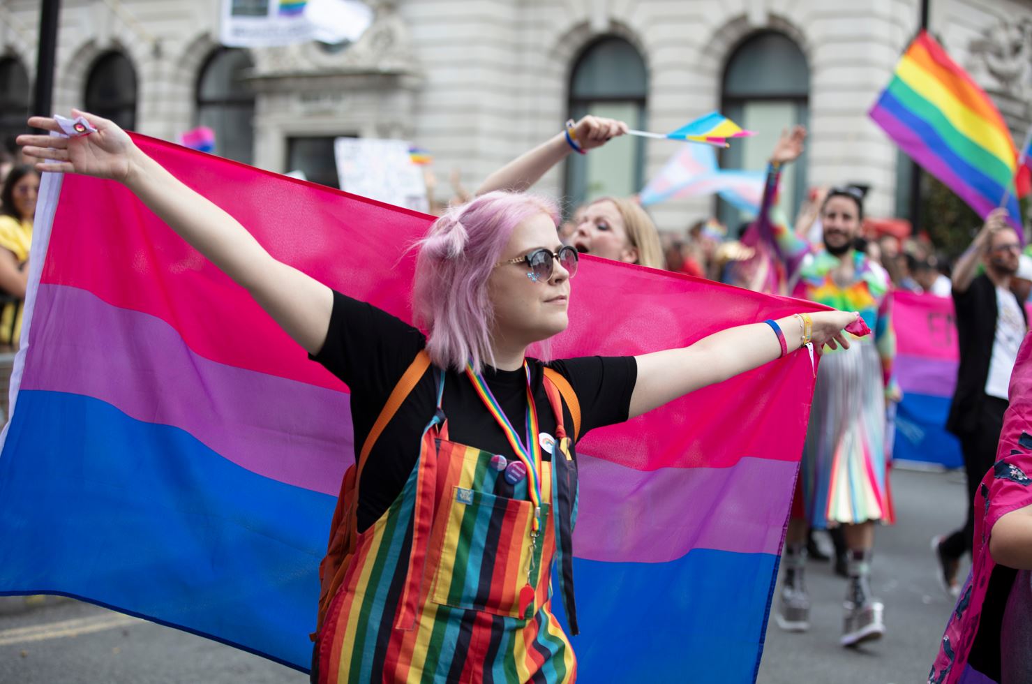 A girl holds a bisexual flag