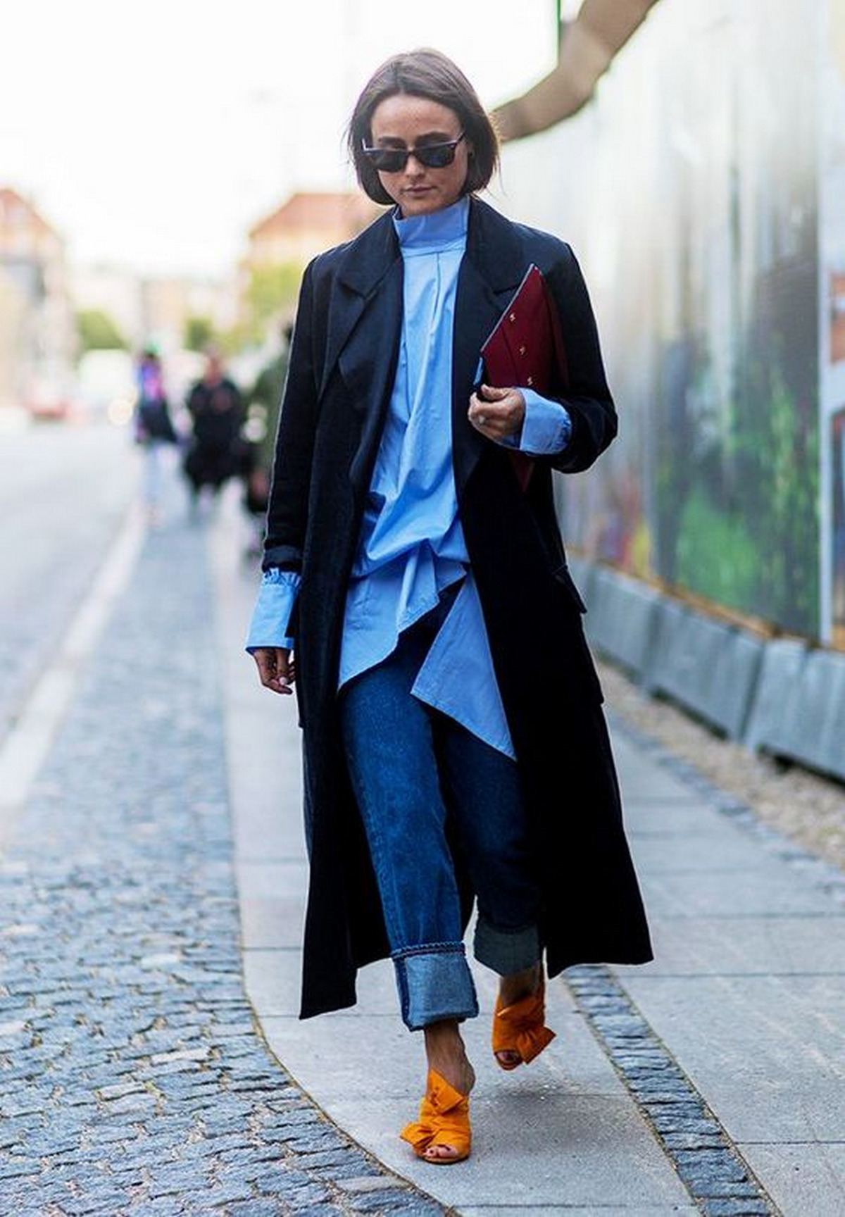 Woman wears black blazer combined with orange shoes.