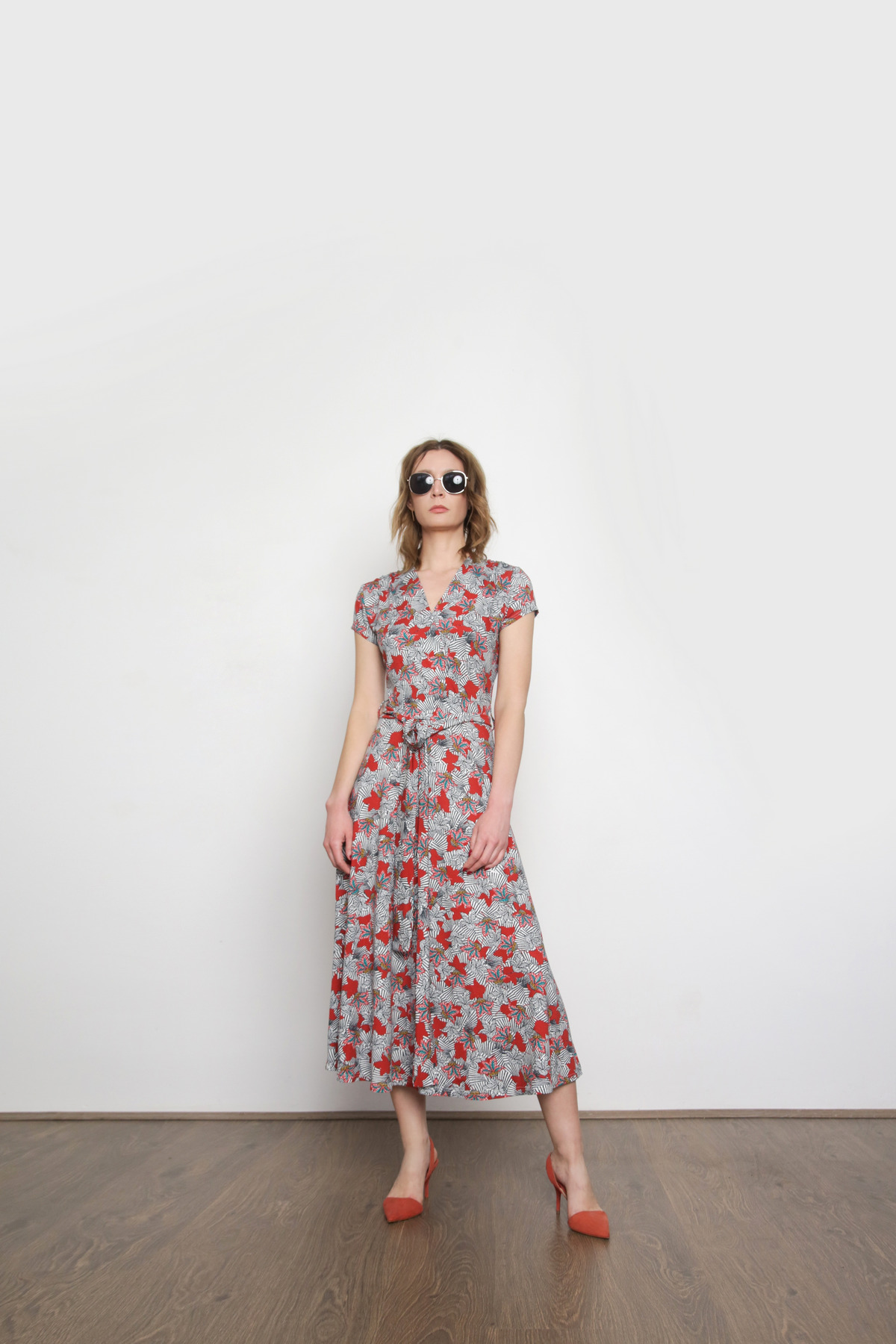 Studio shot of a woman in a floral summer dress.