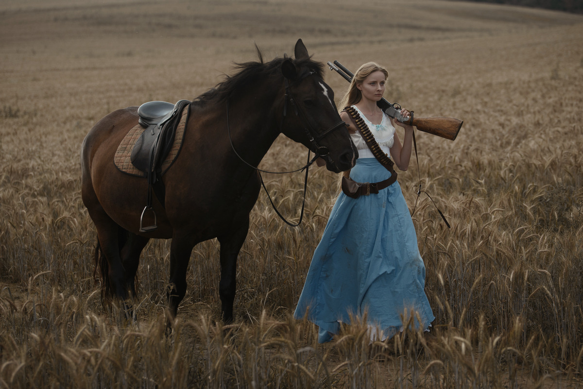 Стильная фотосессия верхом на лошади. Шатенка верхом на лошади. Женщина с короткой стрижкой верхом на лошади бойкая.