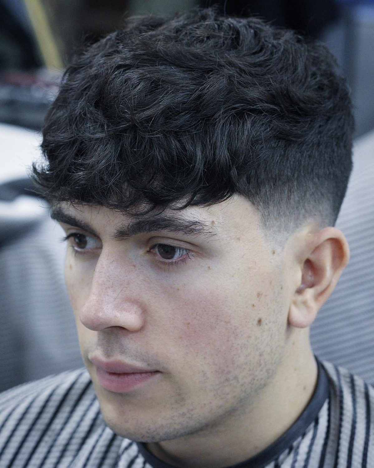 Dark Textured Curly Taper Fade With Bangs