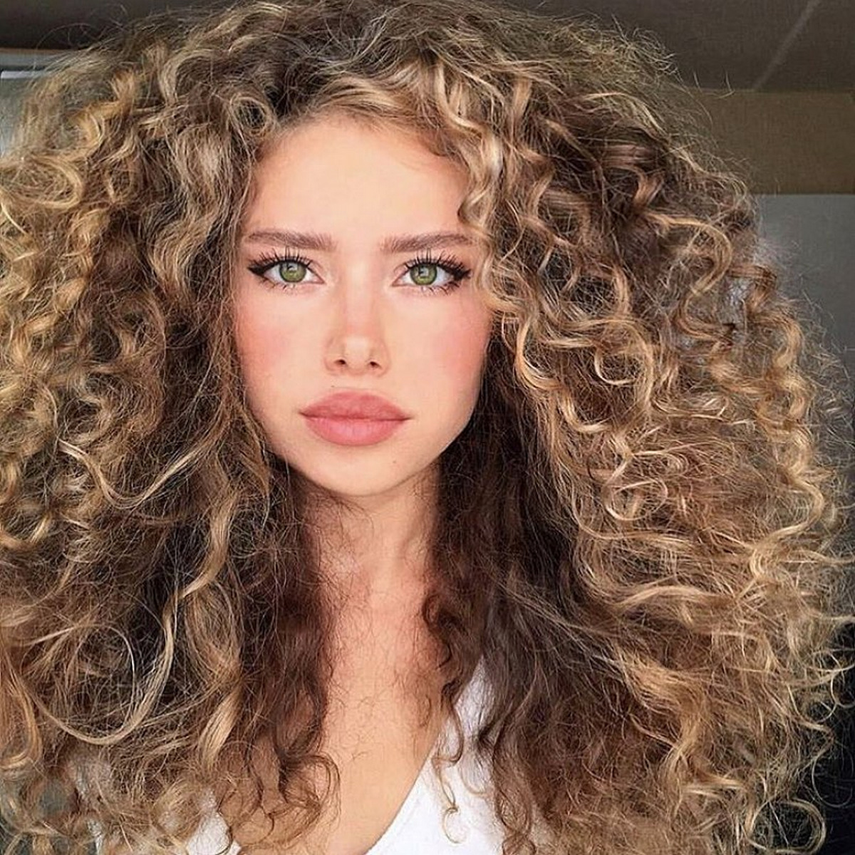 Straight and slightly curly hair of the green-eyed girl