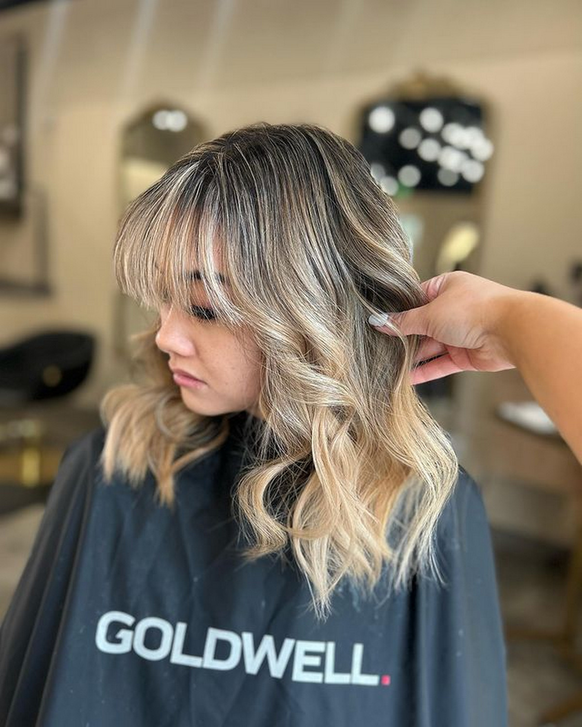 Medium-Length Blonde Hair With Dark Roots And Bangs