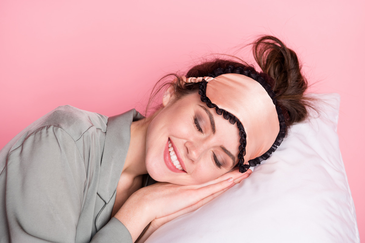 A peaceful young woman sleeping alone and smiling 