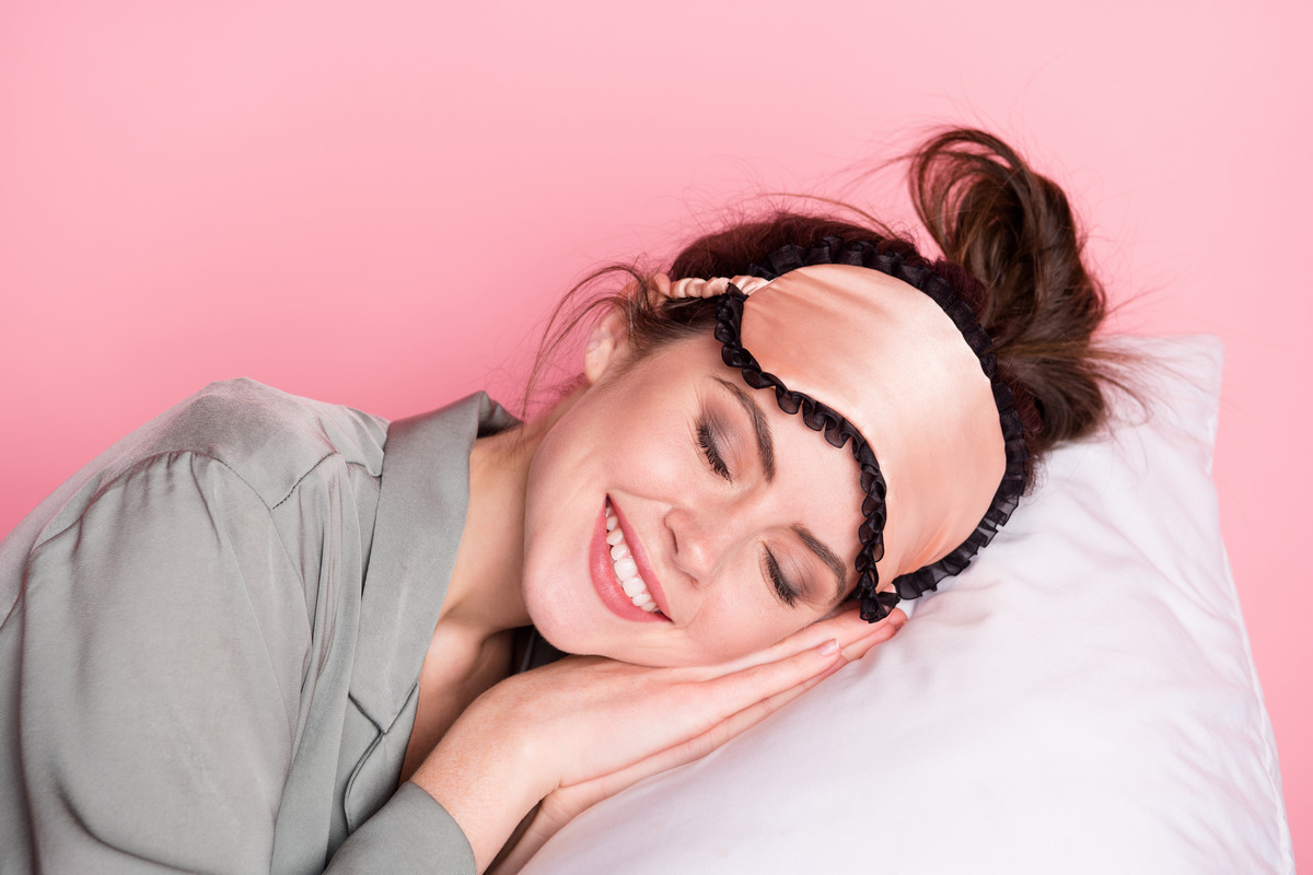 A peaceful young woman sleeping alone and smiling