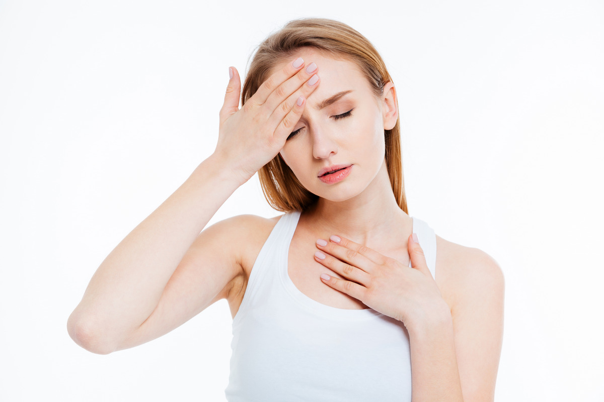 A sick woman touching her head isolated on a white background