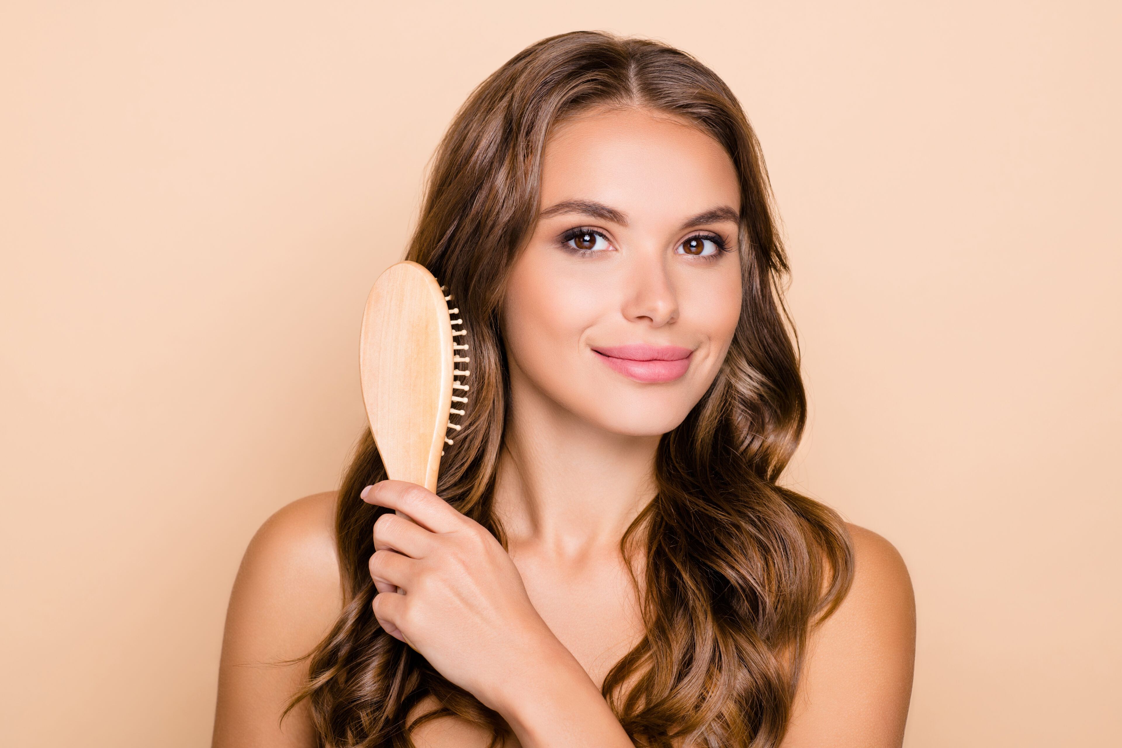 Girl brushing silky perfect brown wavy hair