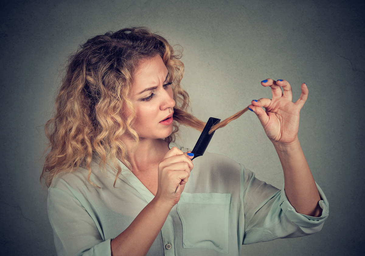 Close-up of a disappointed young woman unhappy with her hair