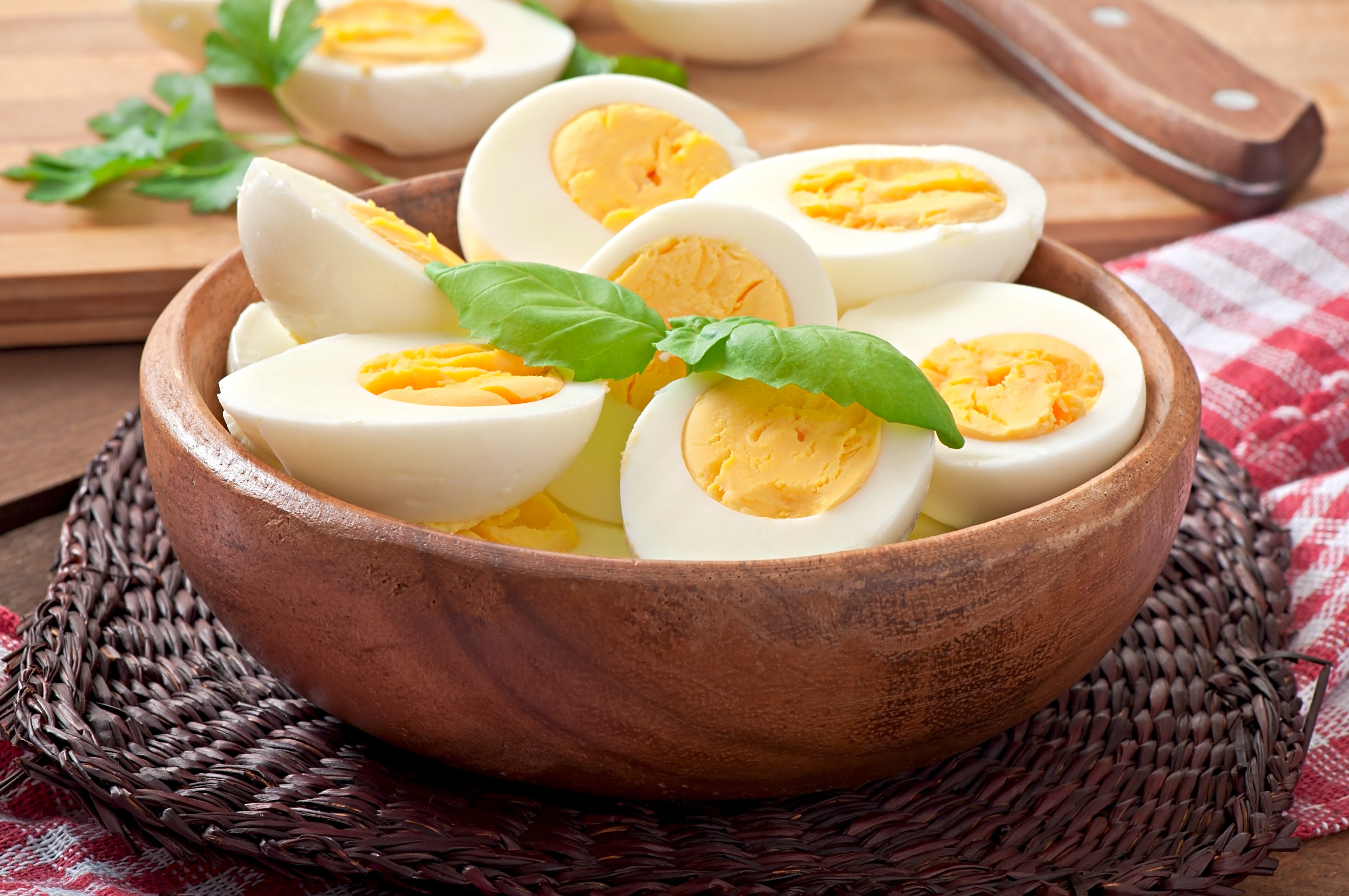 Hard-boiled eggs in a bowl garnished with parsley leaves