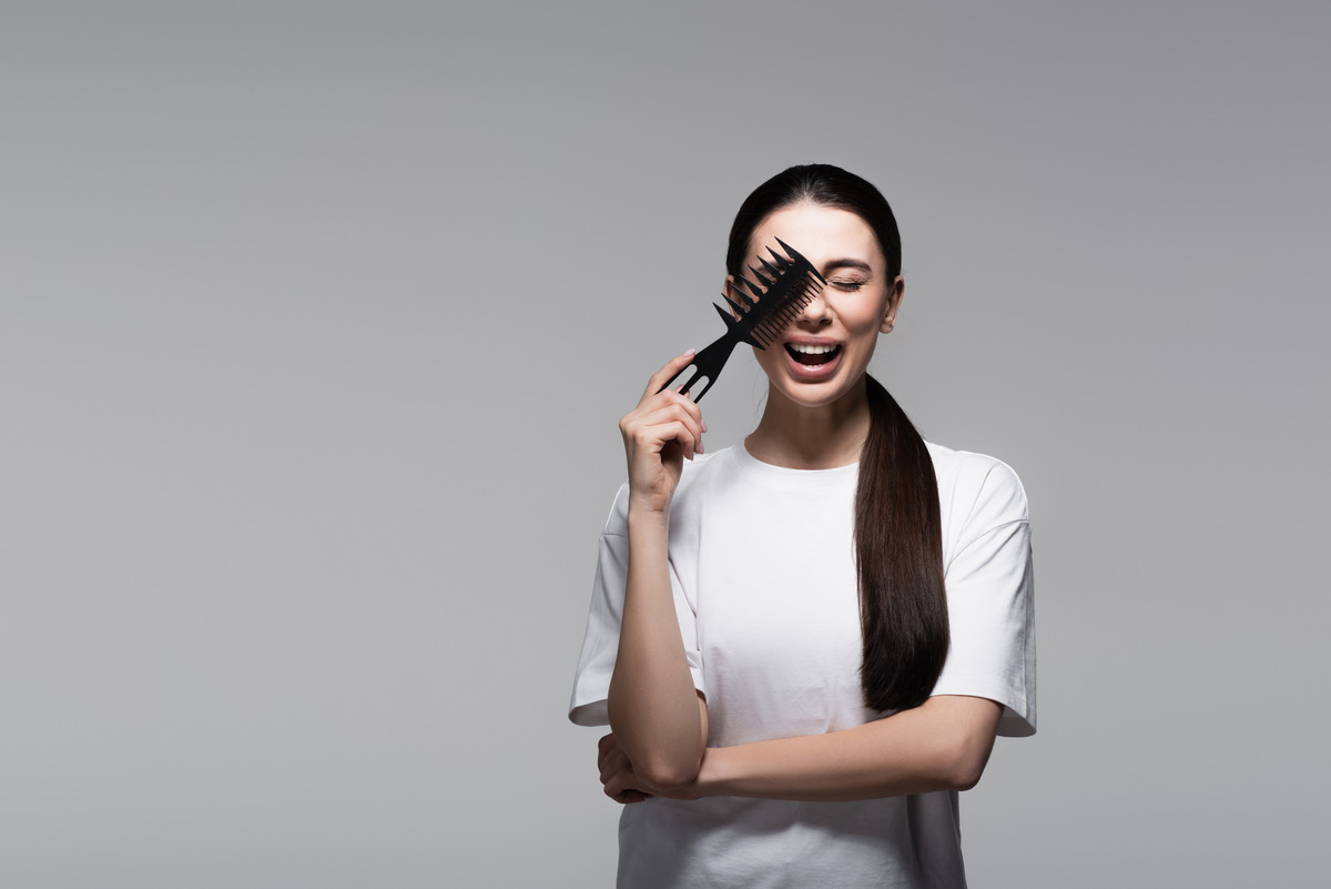 Girl using a wide comb to comb her hair 