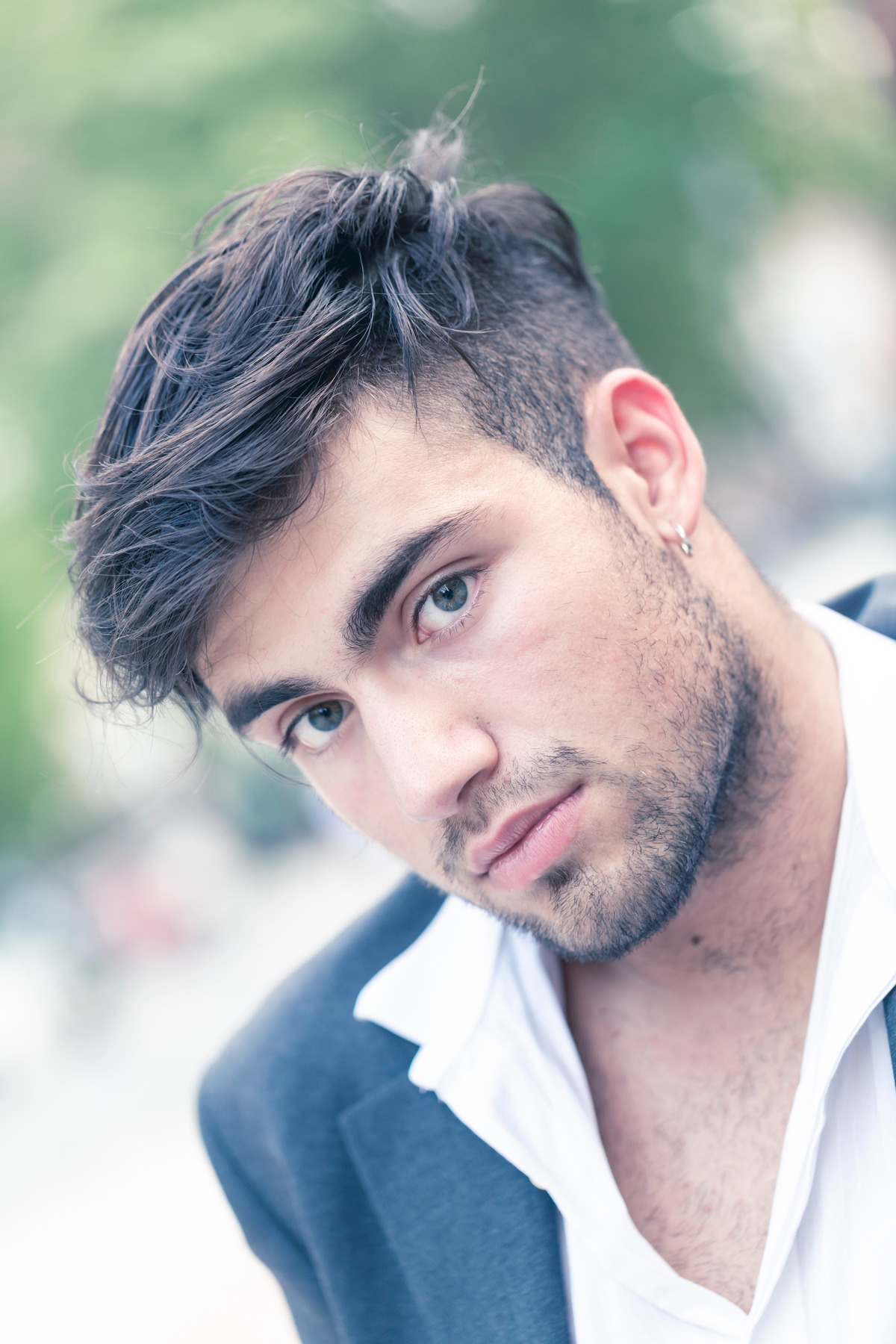 Handsome Italian dark-haired guy sitting portrait