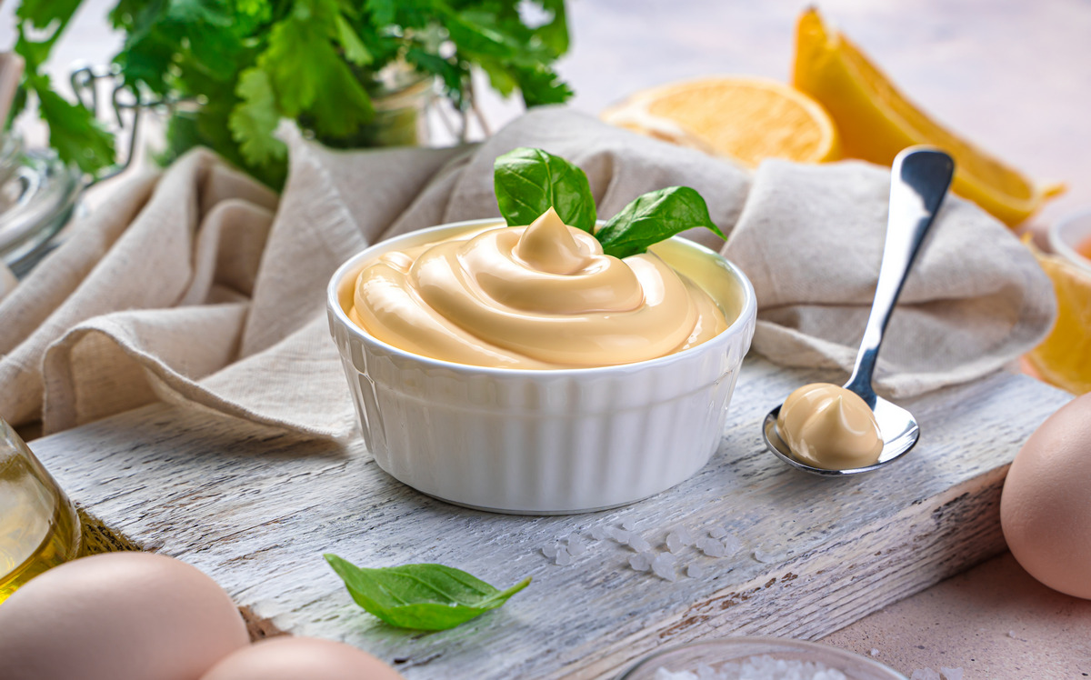 Mayonnaise and natural ingredients on a light background