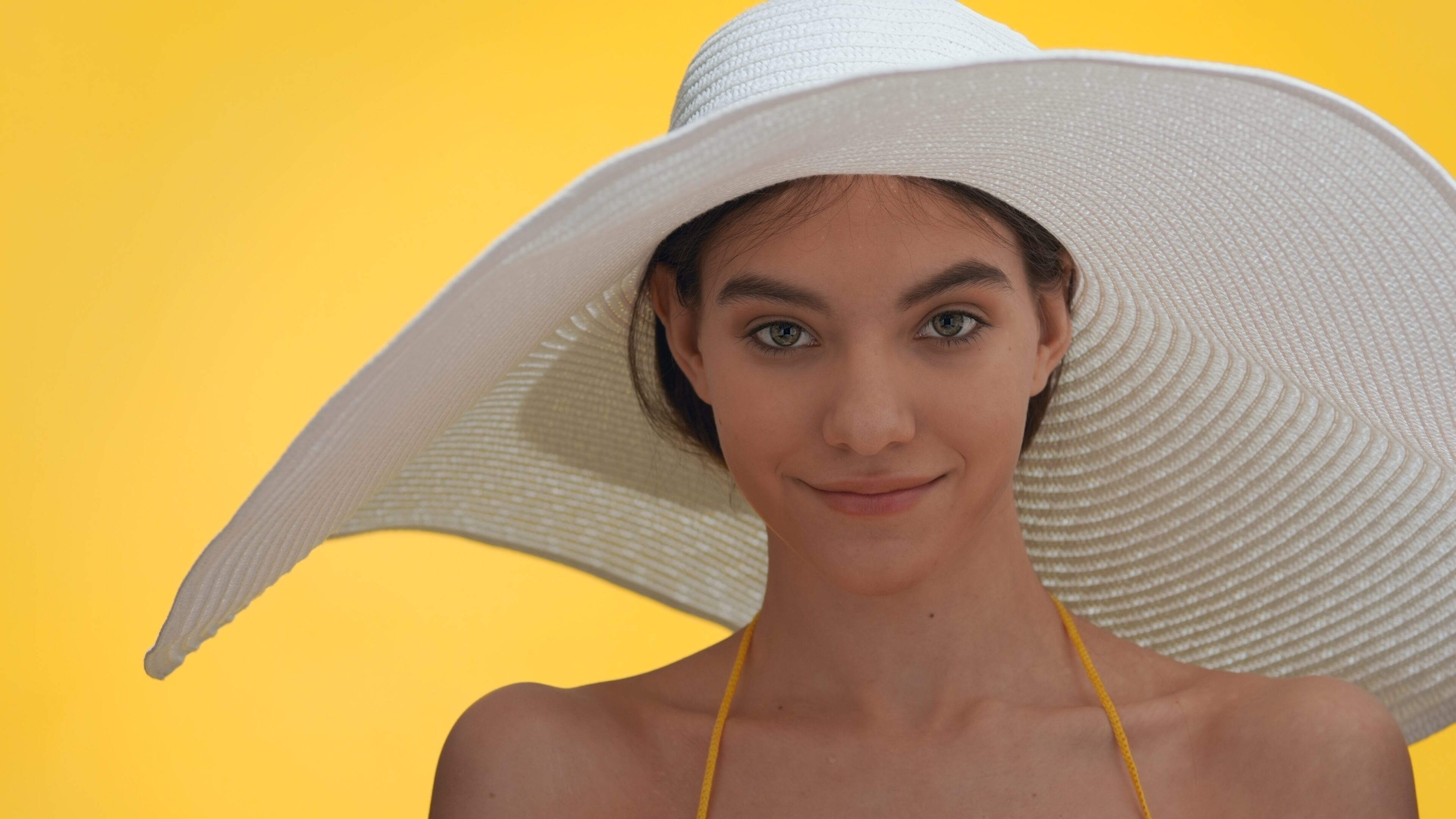 The girl wears a hat to protect her hair from the sun