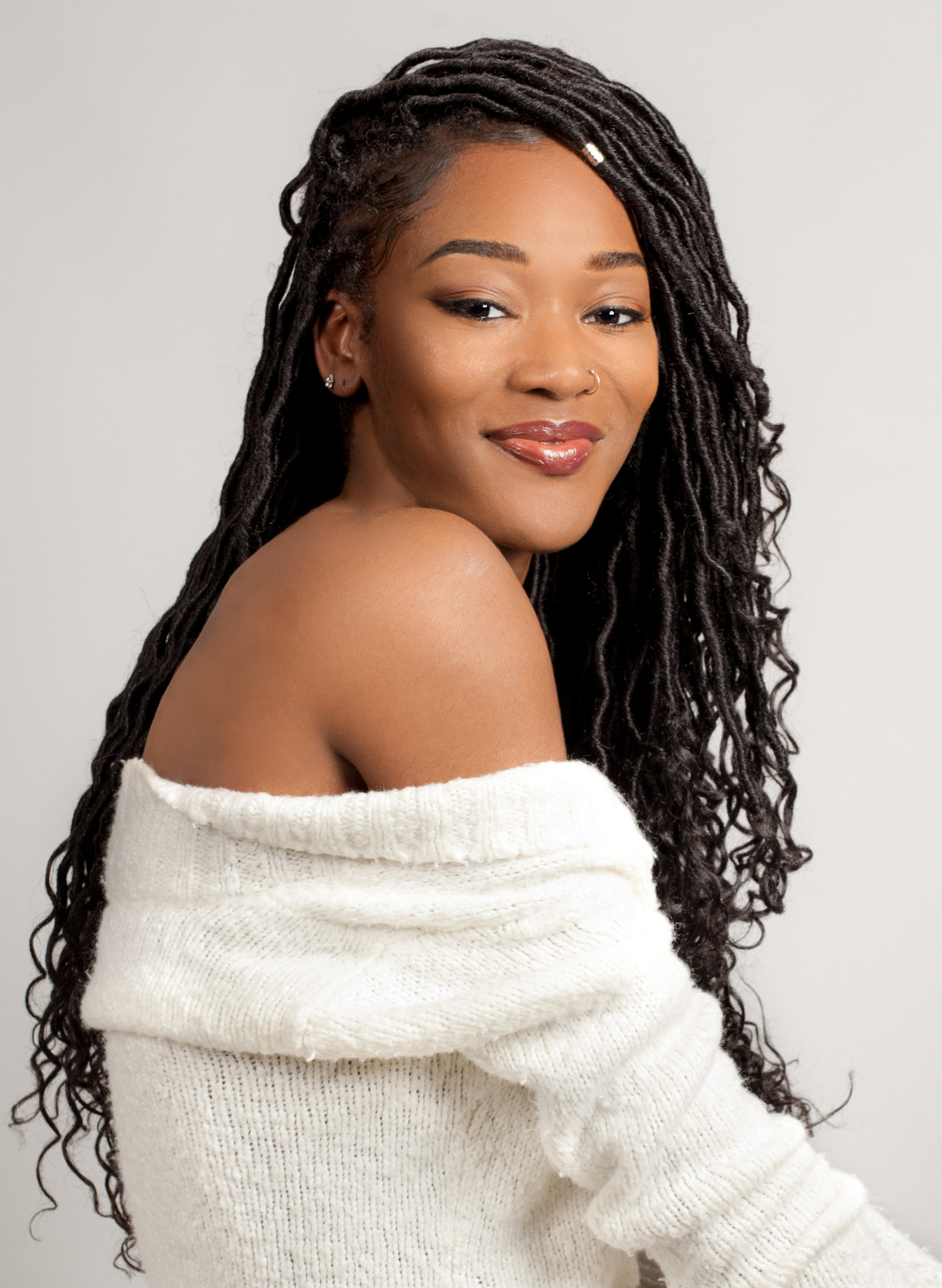 Smiling woman in off-shoulder white sweater