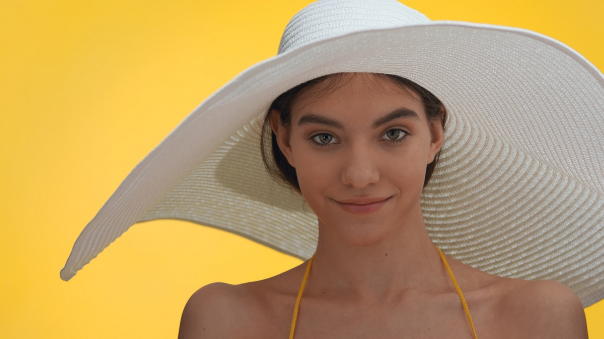 The girl wearing a hat protects her hair from the sun