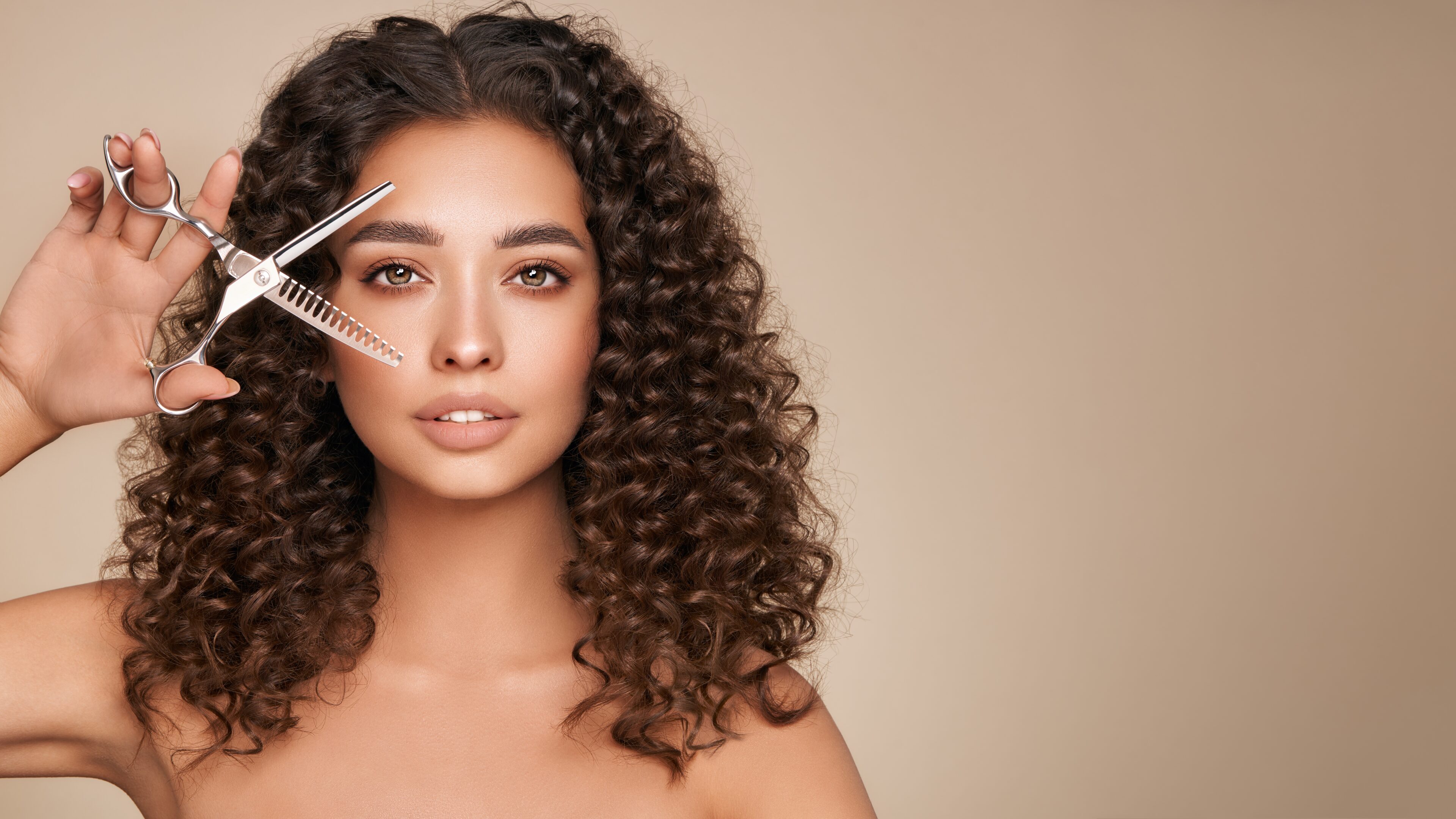 Beautiful young woman with afro hair holds metal scissors