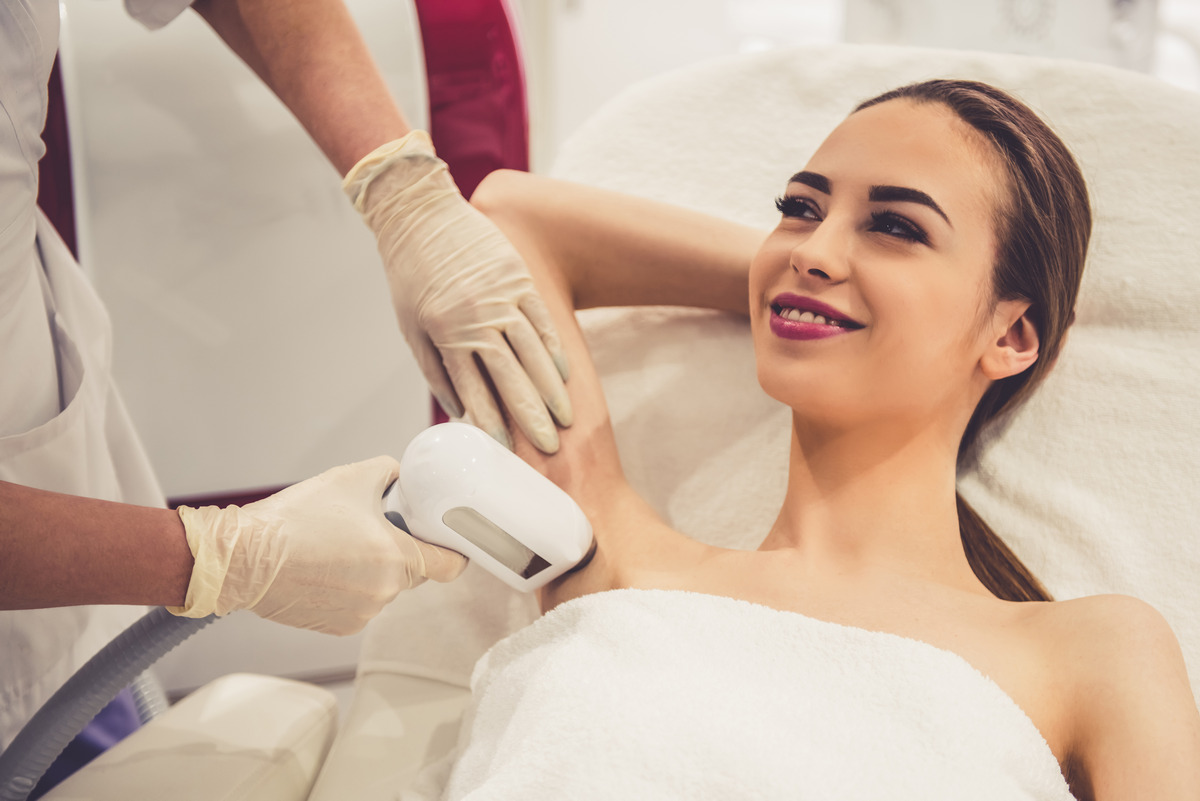 Undertaking the laser epilation of her armpits