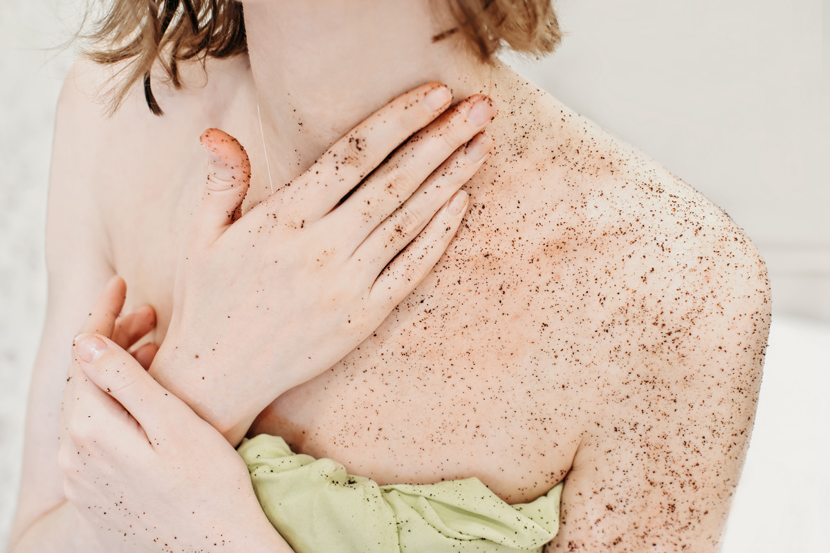Woman applying body exfoliating scrub