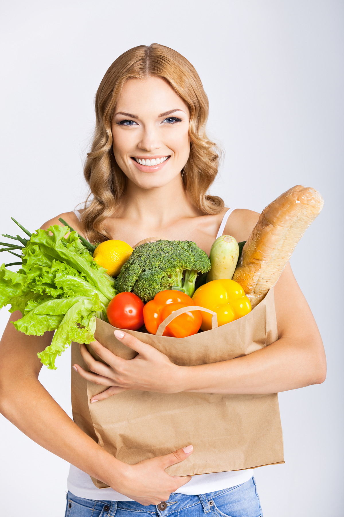 Woman holding grocery shopping bag with healthy vegetarian raw food