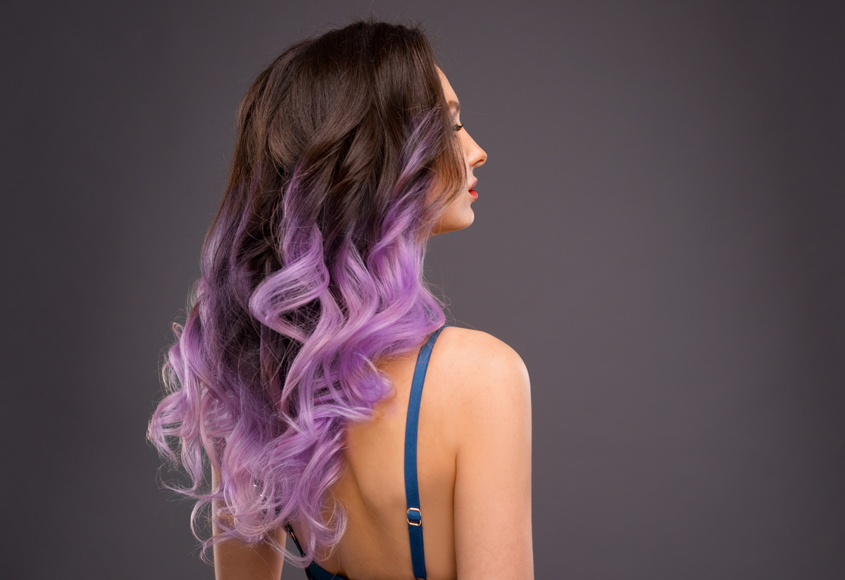 Woman with long healthy colorful ombre lavender wavy hair