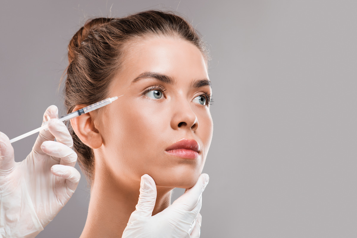 Young beautiful woman getting fillers injections for her eyes area