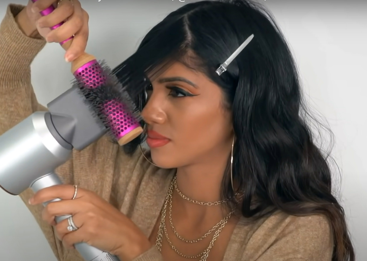 Use the rolling comb and dryer to style your curtain bangs