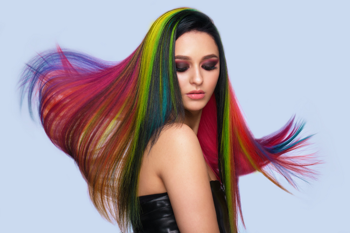 Beautiful woman with multi-colored hair and creative make up and hairstyle