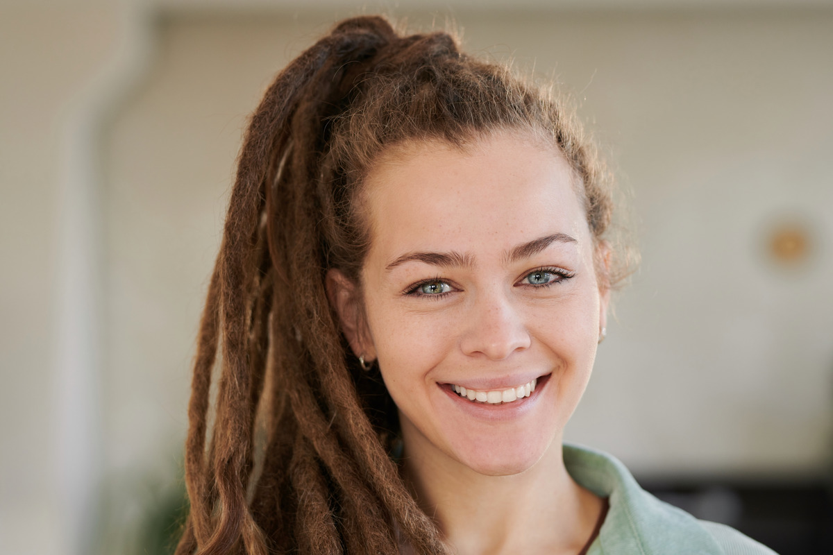 Smiling attractive girl with dreads in a ponytail