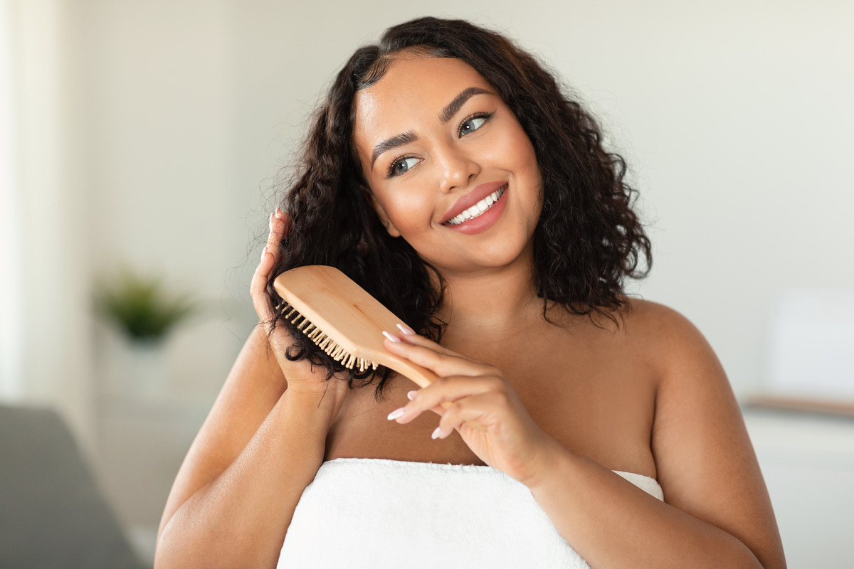 The woman gently detangles with a comb