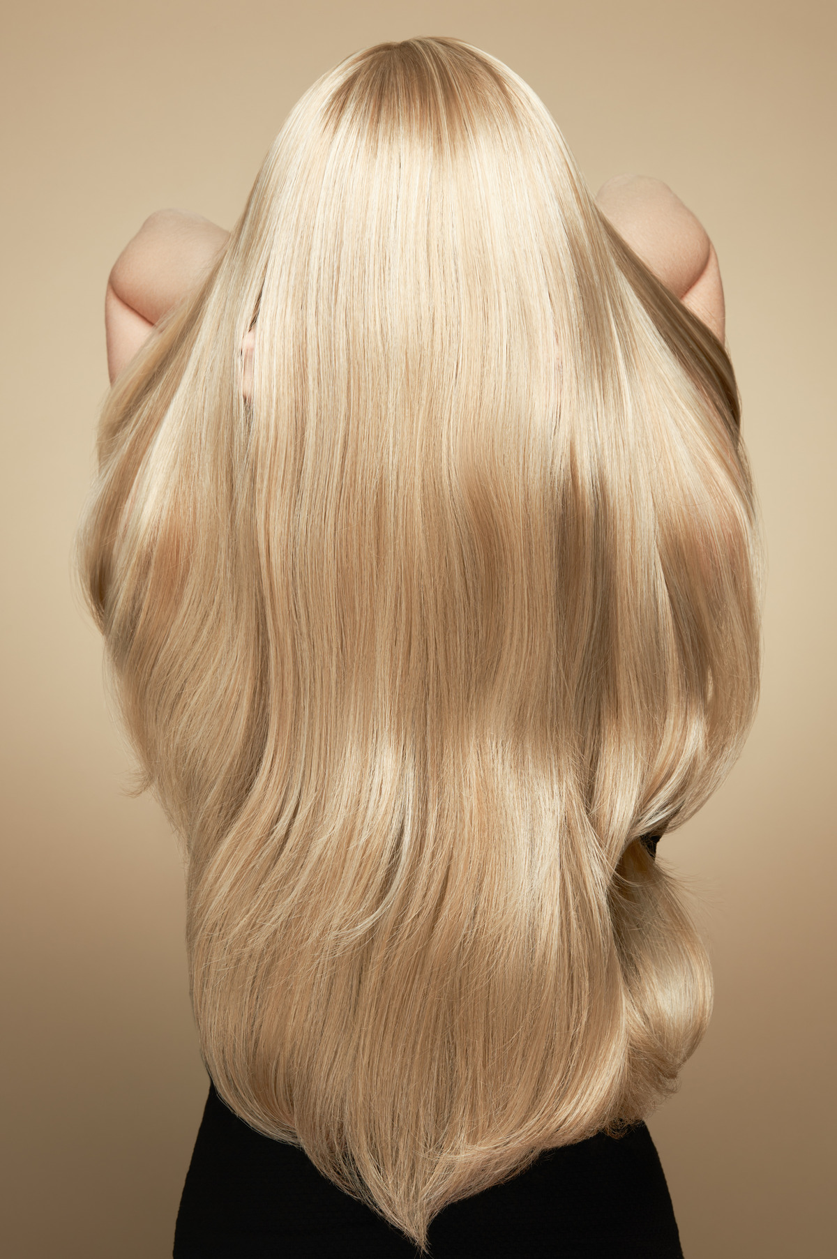 Woman with long beautiful blond hair isolated on beige background